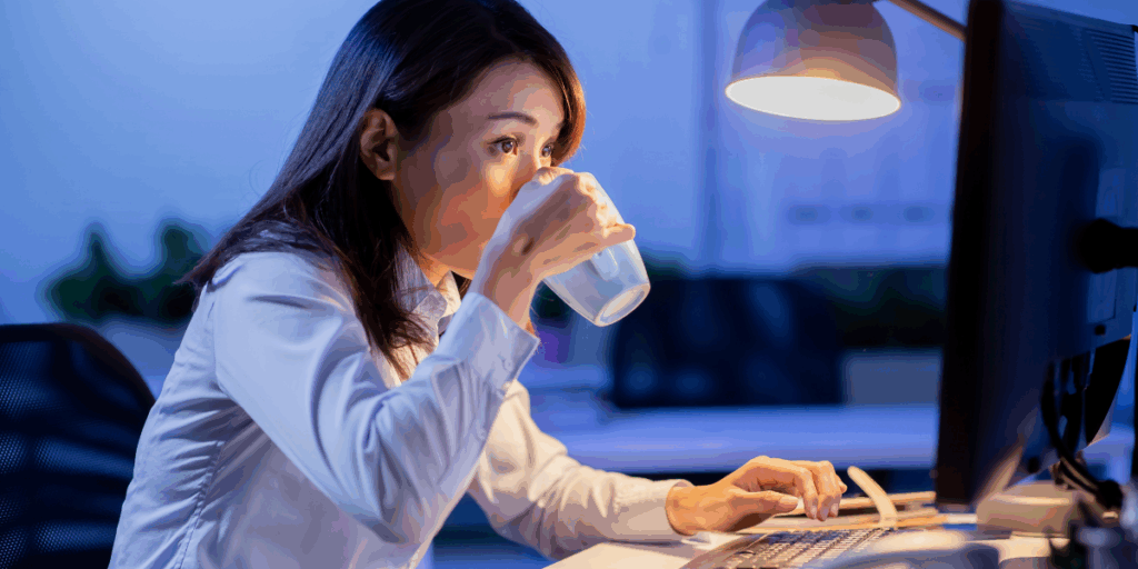 壁の時計を気にしながらデスクで働く社員のイラスト。働く時間のルールや残業代・サービス残業のラインについて解説するコラムのイメージ。